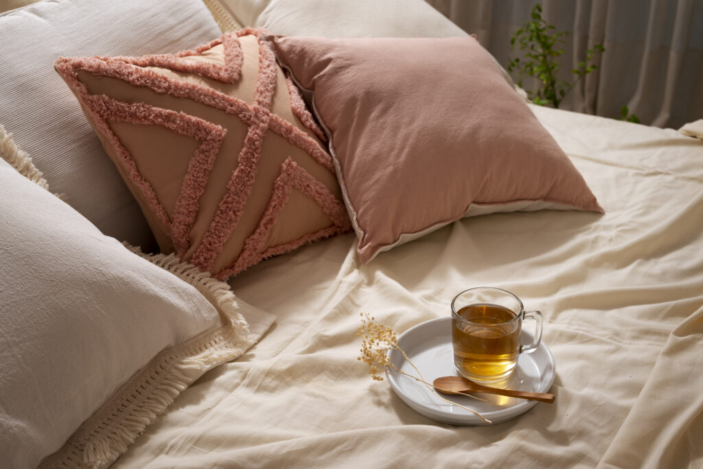 high angle cozy bed arrangement with tea to promote deep sleep