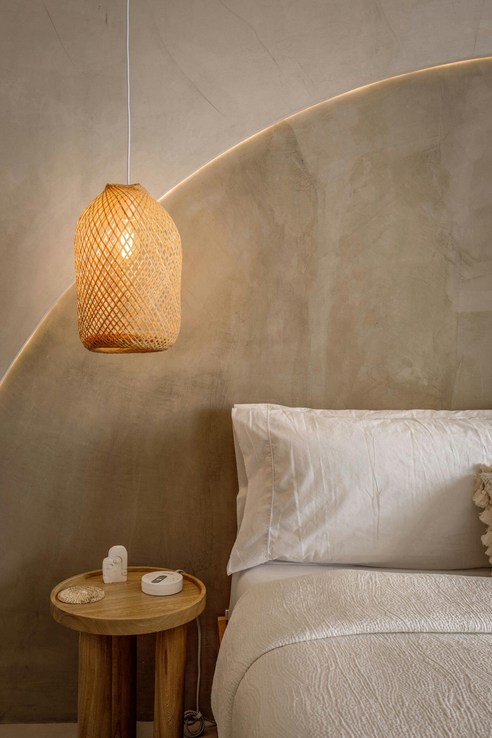 Elegant minimalist bedroom featuring woven lamp and soft white bedding. Sleep help